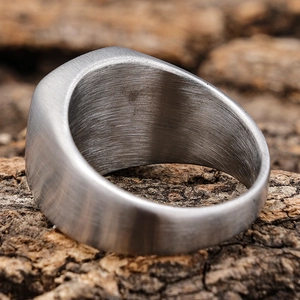 Macro view of brushed stainless steel ring texture on a textured wooden background