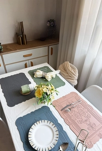 Detail of embossed Nordic faux leather placemats with vintage patterns in four colors
