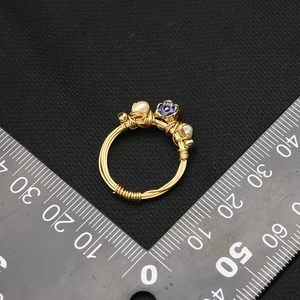 Handcrafted pearl ring with purple flower on gold wire, displayed with metric ruler scale