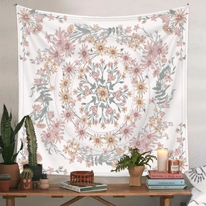 Floral mandala tapestry in pink and yellow hues hanging as wall decor in a cozy room
