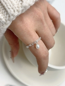 Detailed view of an s925 silver ring featuring a hollow heart chain and a pearl pendant