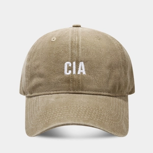 Detailed view of khaki washed cotton baseball cap with white CIA 3D embroidery