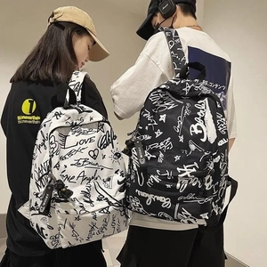 Detail of street-style graffiti backpacks shown on a couple in a modern indoor setting