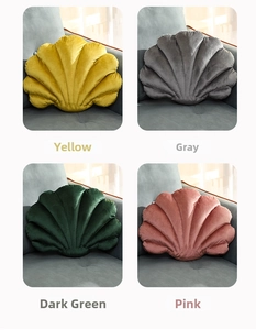 Detail view of shell-shaped velvet pillows in yellow, gray, green, and pink colors