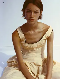 Détail d'une robe sans manches beige avec liseré noir et corsage plissé de style rétro chic