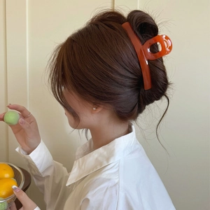Large amber orange butterfly hair claw clip for elegant women styling on white background
