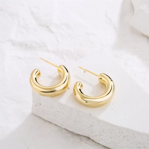 Minimalist 14K gold plated smooth hoop earrings displayed on white stone texture background