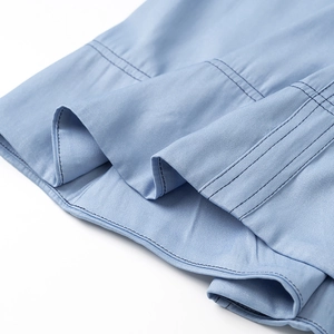 Vista macro del tessuto denim azzurro e dettagli delle doppie cuciture sull'orlo