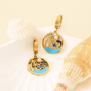 Detail of gold dolphin earrings with coconut tree, blue enamel, and white pearl