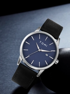 Detail of minimalist blue dial watch with date display window and black leather strap