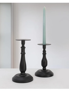 Detail of matte black wrought iron candle holders with long stems and round stable base