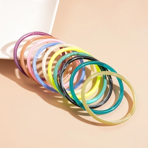 Set of 10 colorful acrylic bangles in vibrant resin tones on a neutral background