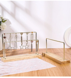 Detail of wooden base earring display stand with golden metal racks and jewelry