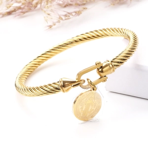 Detail of gold-plated twisted cable bracelet with U-hook and Saint Benedict medal