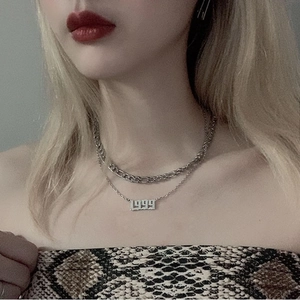 Detailed view of layered silver necklace featuring a 1999 birth year number pendant