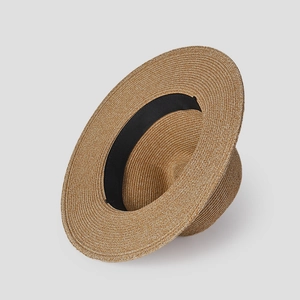 Detailed view of brown woven straw hat with inner black sweatband and wide flat brim