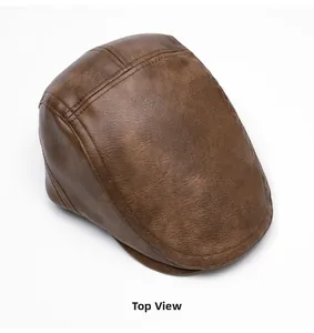 Top view of brown leather newsboy cap showing detailed pebble grain texture and stitching