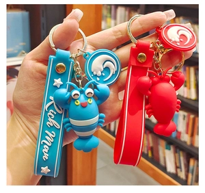Detail of red and blue cartoon lobster keychains with silicone wristband and metal hook