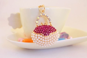 Detail of a gold handbag keychain with rose pink pearls and sparkling rhinestones