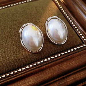 Detailed view of large oval pearls with elegant silver metal edges on a vintage tray