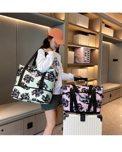 Detail showing mint green and pink elephant print travel bags fixed on a luggage handle