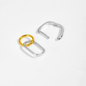 Detailed view of bicolor oval and silver rectangular link earrings in minimalist style
