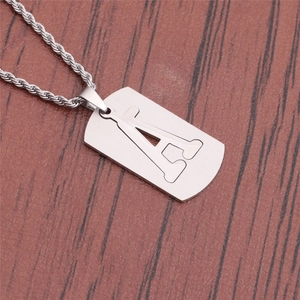 Gros plan sur la chaîne torsadée en titane et le pendentif rectangulaire ajouré A