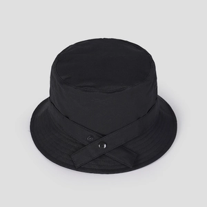 Detail of black nylon bucket hat featuring crossover straps and reinforced brim stitching