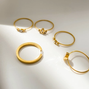 Five-piece gold ring set featuring crown, three-stone, and marquise cut crystal designs