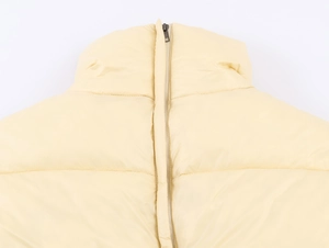 Detail of hooded cotton jacket collar featuring cream quilting and a dark metal zipper