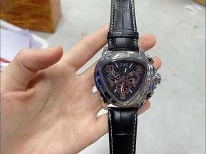 Detailed close-up of a silver triangle automatic mechanical watch with a black leather strap