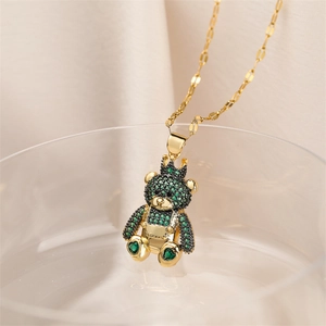 Detailed macro view of a gold-plated crown bear pendant with green micro-pave zircons