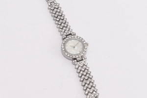 Detailed close-up of a silver ladies watch with a shimmering shell face and rhinestone strap