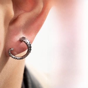 Detailed view of punk octopus tentacle ear cuff with realistic suction cups on metal