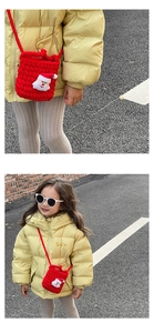 Detail of red handmade knit Santa bag paired with a vibrant yellow kids' down jacket