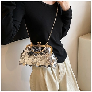 Elegant gold sequin evening clutch bag with metal chain strap worn by a female model