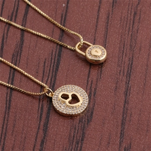 Collane minimaliste in oro con pendente a cuore e lucchetto in zirconi su legno scuro