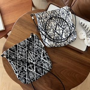 Detailed close-up of embroidered canvas crossbody mini bags with intricate bird and floral patterns