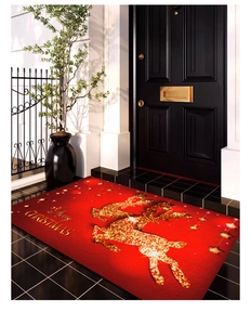 Détail du tapis de Noël rouge avec renne doré et message Merry Christmas dans une entrée