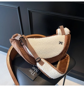Detail of plush brown suede and white faux fur crossbody bag with cute black bow accent