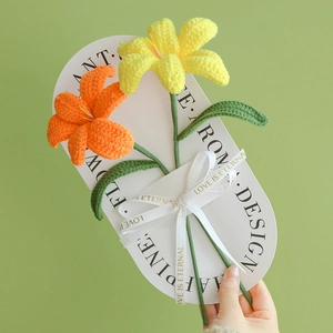 Handmade crochet lily bouquet with yellow and orange yarn flowers in elegant gift wrap