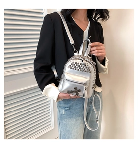 Detail of silver studded mini backpack with punk cross pendant and metal chains