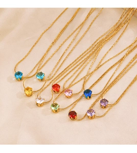 Detail of colorful twelve month zircon necklaces with gold chain on silk background