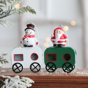 Christmas train ornaments with Santa and Snowman figures on snow-covered wood