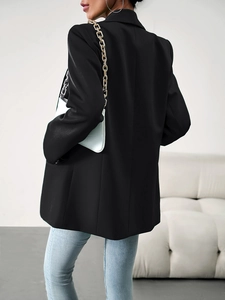 Vue arrière d'un blazer noir cintré pour femme montrant la coupe professionnelle