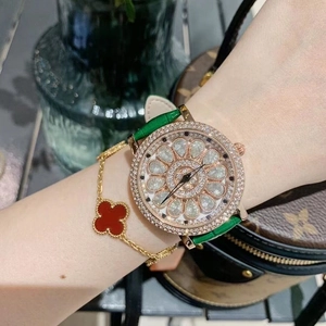 Detail of luxury spinning flower dial with sparkling rhinestones and green leather strap