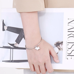 Bracelet jonc en argent poli avec pendentif cochon 3D porté au poignet d'un mannequin