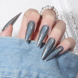 Macro shot of long stiletto press-on nails with grey holographic laser glitter effect