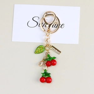 Macro shot of cherry keychain with handmade metal tag and red fruit charms on card