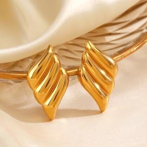 Modern gold-plated wavy flame-textured earrings on elegant satin background